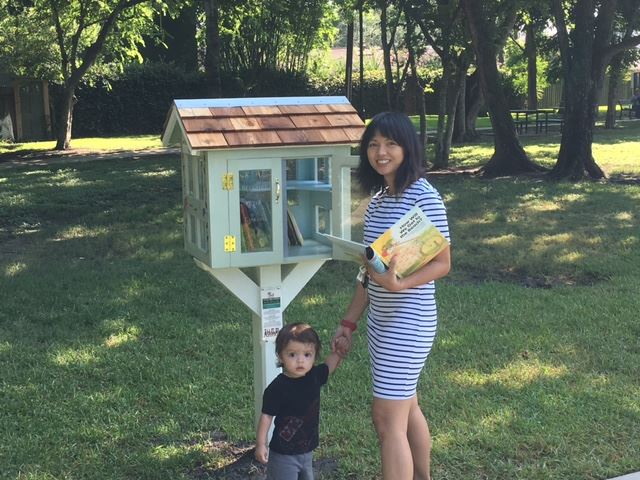 Mother and son picking books from the little free library